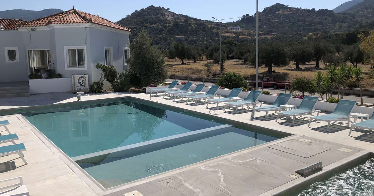 Saltwater pool with loungers and Lesvos hills beyond